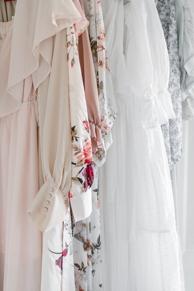 Multiple flowy dresses hanging on a rack