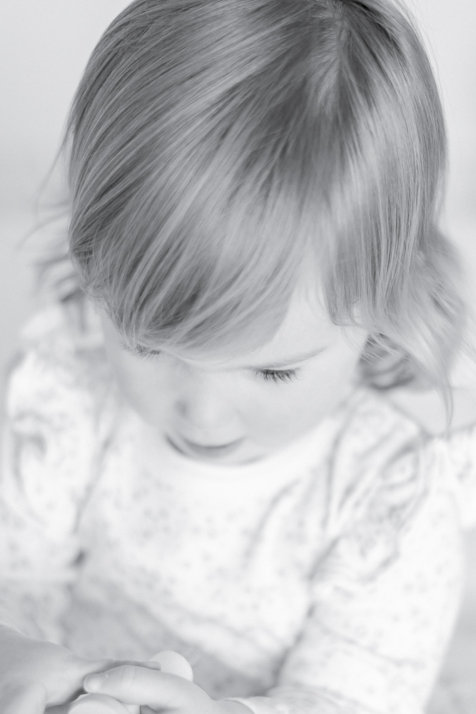Black and white image of a young girl's soft curls and thick eyelashes