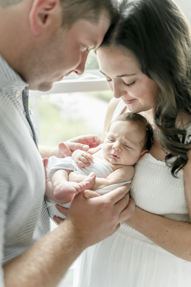 A newborn is held closely by his parents