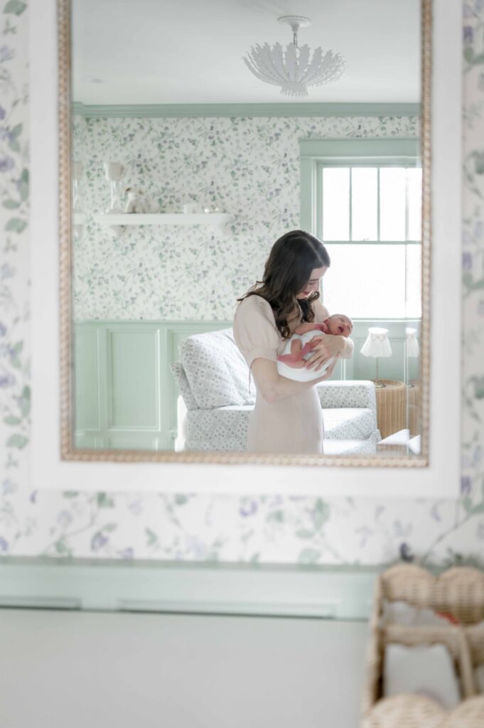Mirror reflection of a mother holding her newborn baby girl