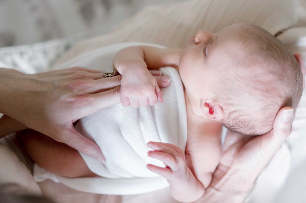 Newborn fingers grasp her mother's hand