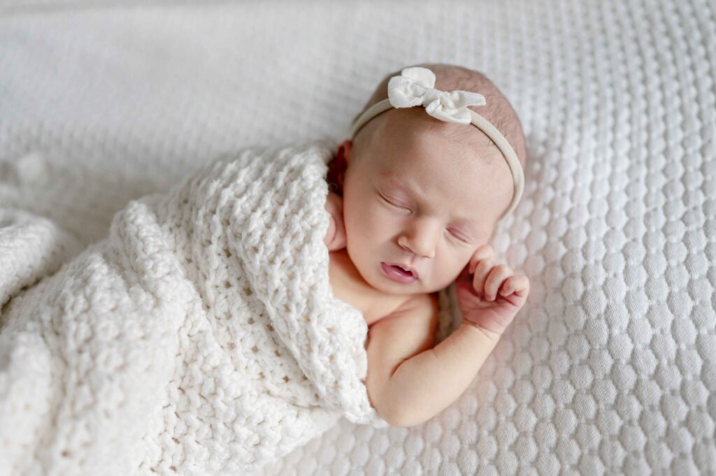 newborn baby wrapped in a white swaddle