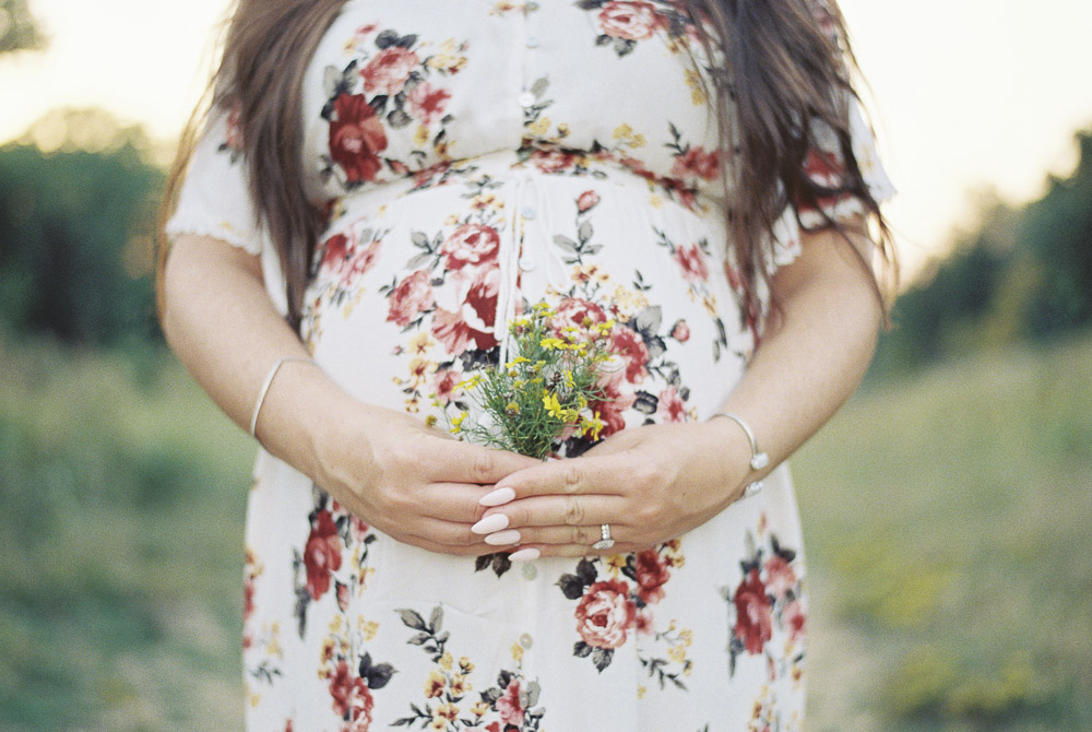 yellow flowers in front of a pregnant stomach.