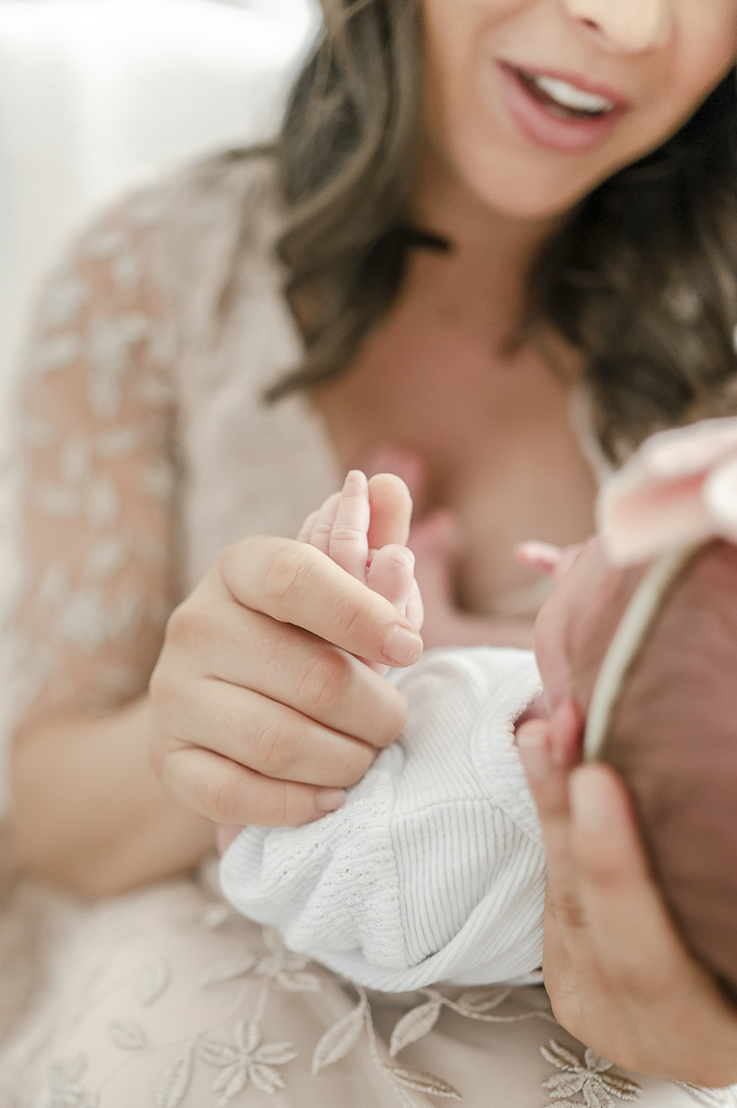A mother holds her newborn's fingers