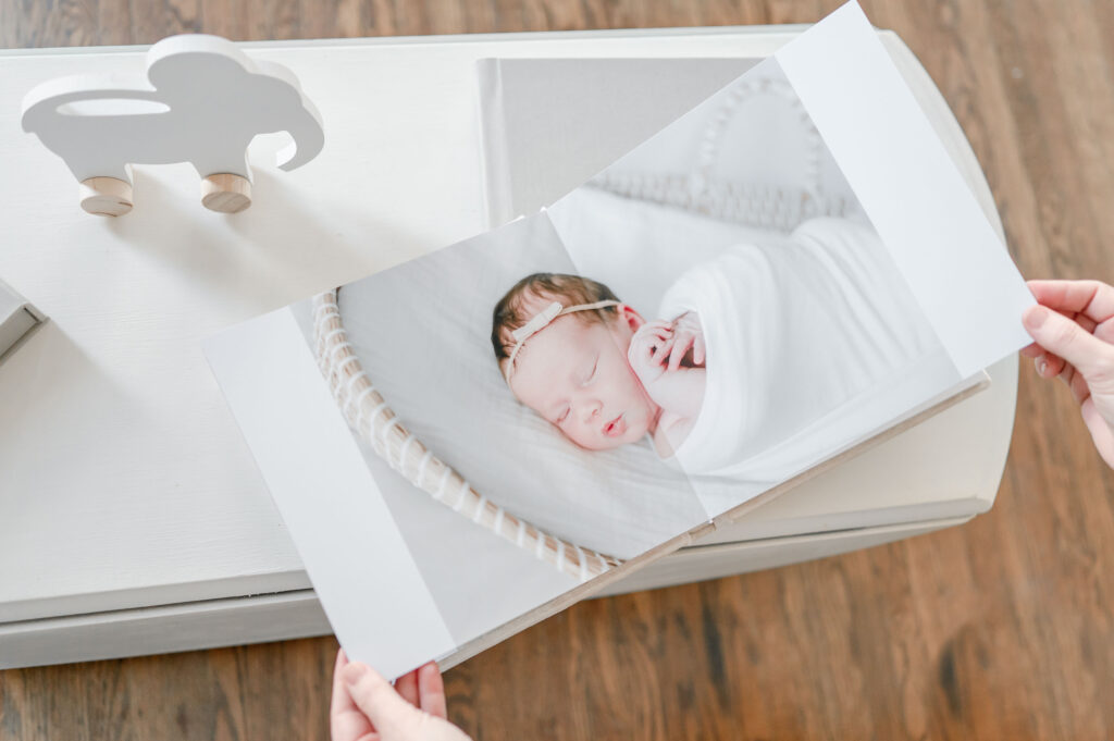 Newborn baby on a photo album page in Kristie Lloyd's Nashville Maternity and Newborn Photographer Studio