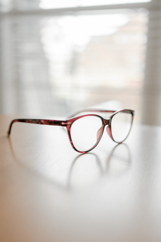 Brown glasses sit on a desk photographed with aperture at f1.8