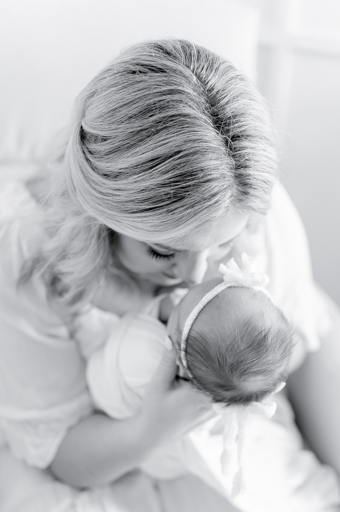 A soft black and white image of a mother giving eskimo kisses to her newborn baby  by Brentwood newborn photographer Kristie Lloyd.