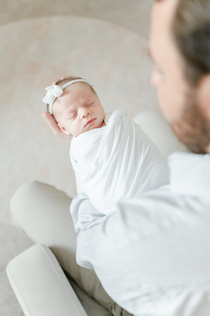 A newborn baby is help in her father hand  by Brentwood newborn photographer Kristie Lloyd.