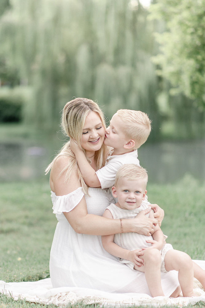 A mother smiles with her two sons as they sit in front of a weeping willow Franklin TN Maternity photographer Kristie Lloyd.