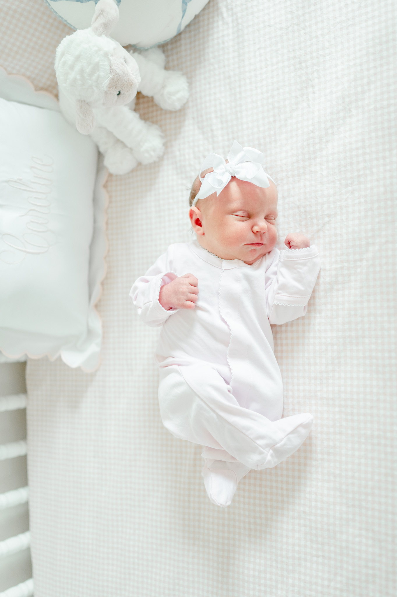 Newborn baby girl sleeps in her crib by natural newborn photographer Kristie Lloyd