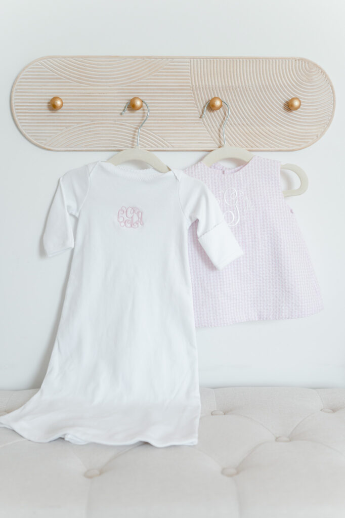 Nursery inspiration: monogramed baby dresses hang on wall hooks