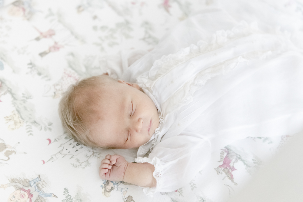 Sleeping newborn wears a feltman brother's gown