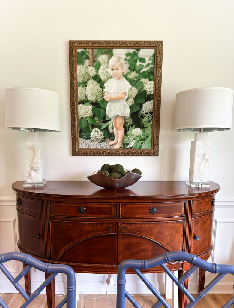 Large framed canvas of a 2 year old boy portrait hangs on a wall above a buffet in a Franklin TN family's home