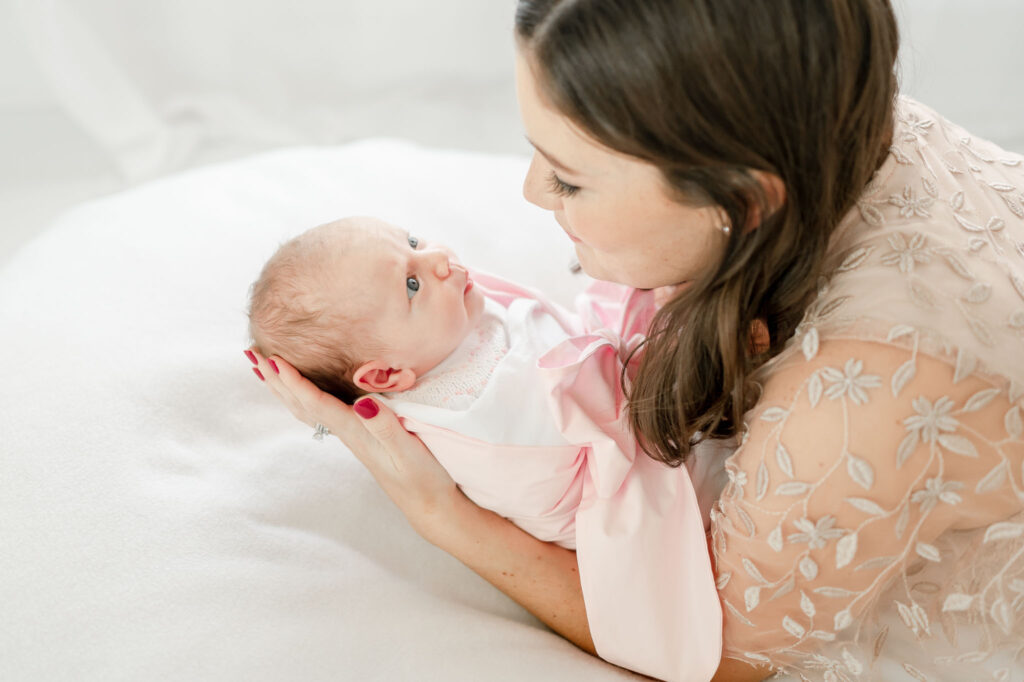 Mother gazes at her newborn baby girl 