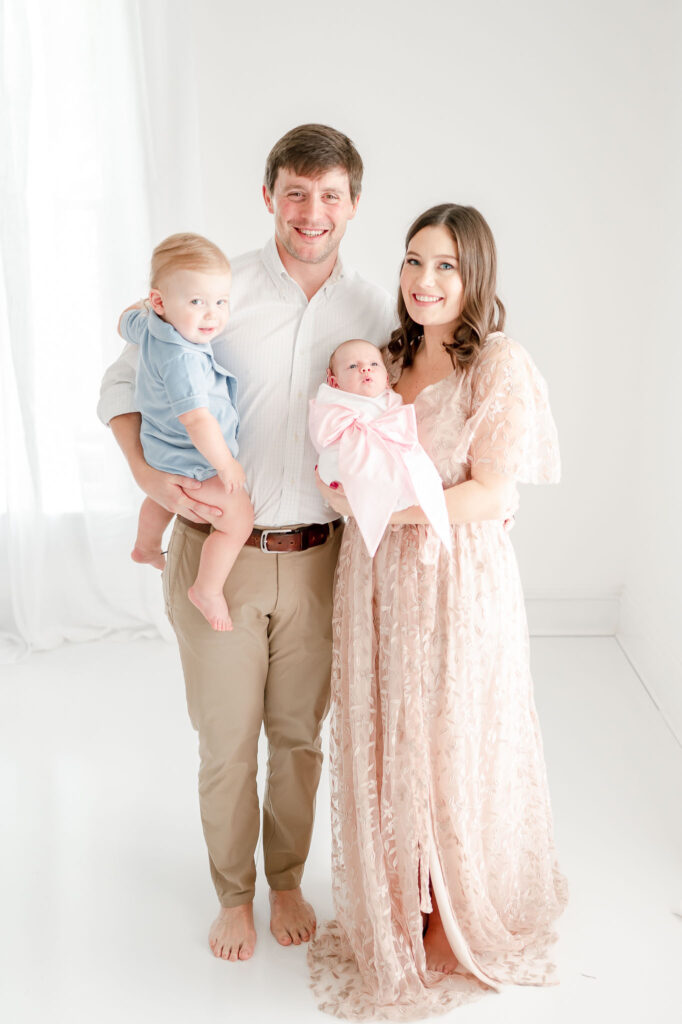 Family studio newborn session with a mom, dad, toddler, and baby girl