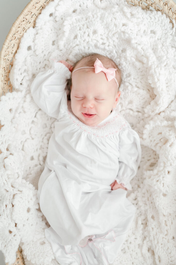 Newborn girl sleeps in a Moses basket