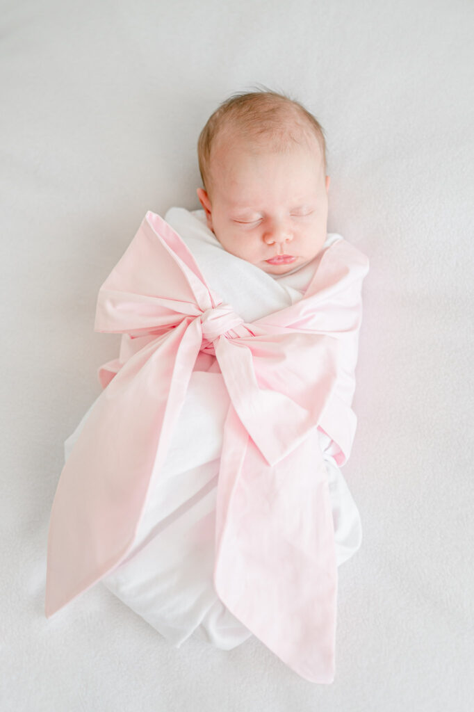 Newborn baby girl in a Beaufort Bonnet Bow Swaddle