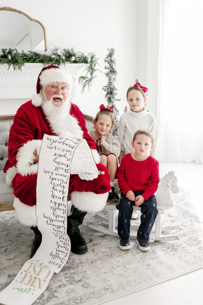 3 siblings smile as they sit with Santa in Kristie Lloyd's studio