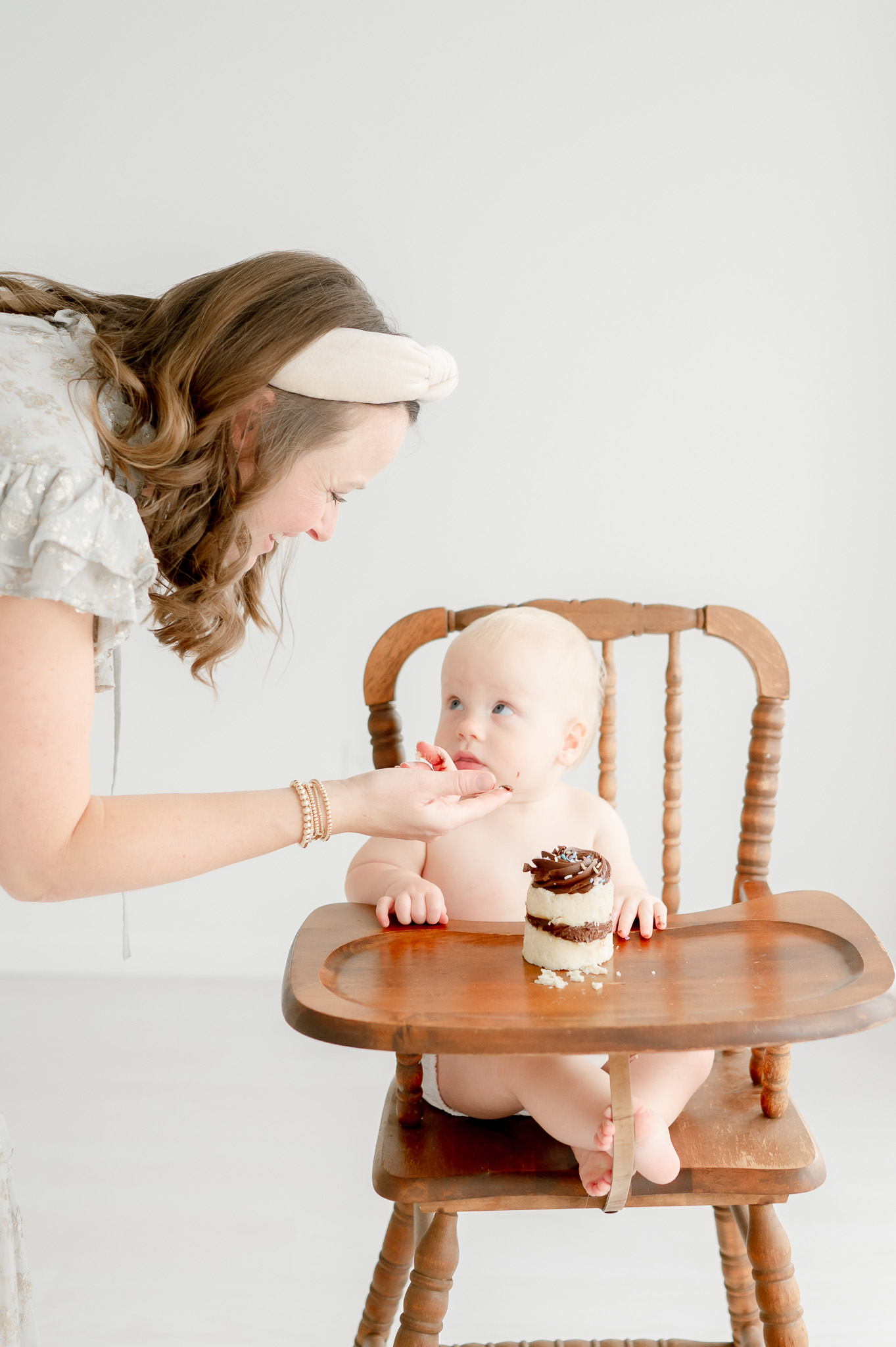 A mother gives her baby a taste of cake