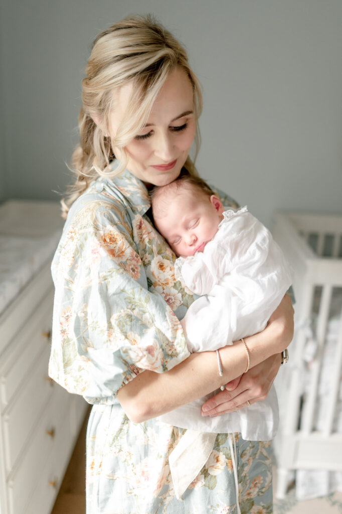 A mother holds her sleeping newborn against her chest