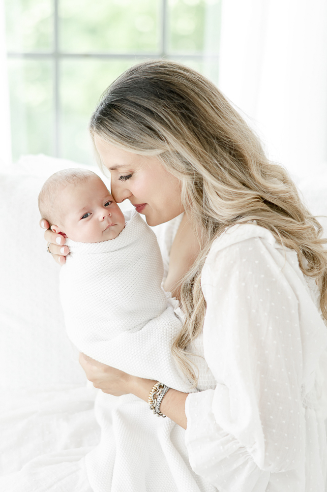 A mother smells her new baby's cheek: Postpartum Photo Tips for Nashville Moms